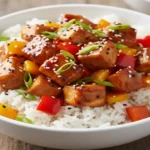 Frango Teriyaki caseiro com molho brilhante sobre arroz branco.